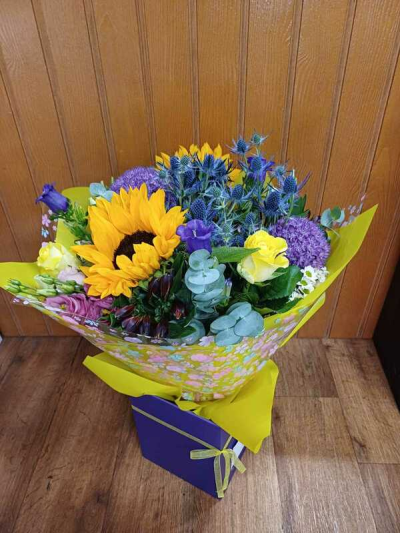 Summer Days - A Beautiful mix of purple and yellow flowers would definitely bring a smile to the recipient. Sunflowers will be included if in stock.
