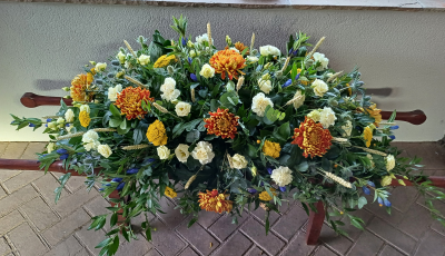 Casket Spray - Autumnal - A beautiful classic tribute using a mix of autumnal coloured seasonal flowers with foliage. Please call before ordering to discuss if there are specific flowers you would like.
